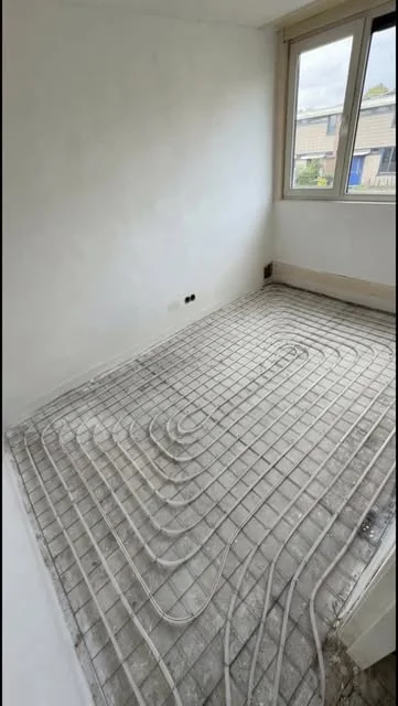 Aangelegde vloerverwarming in een ruimte vóór de vloerafwerking